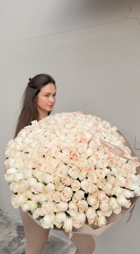 Woman holding an oversized birthday bouquet of 250 blush roses