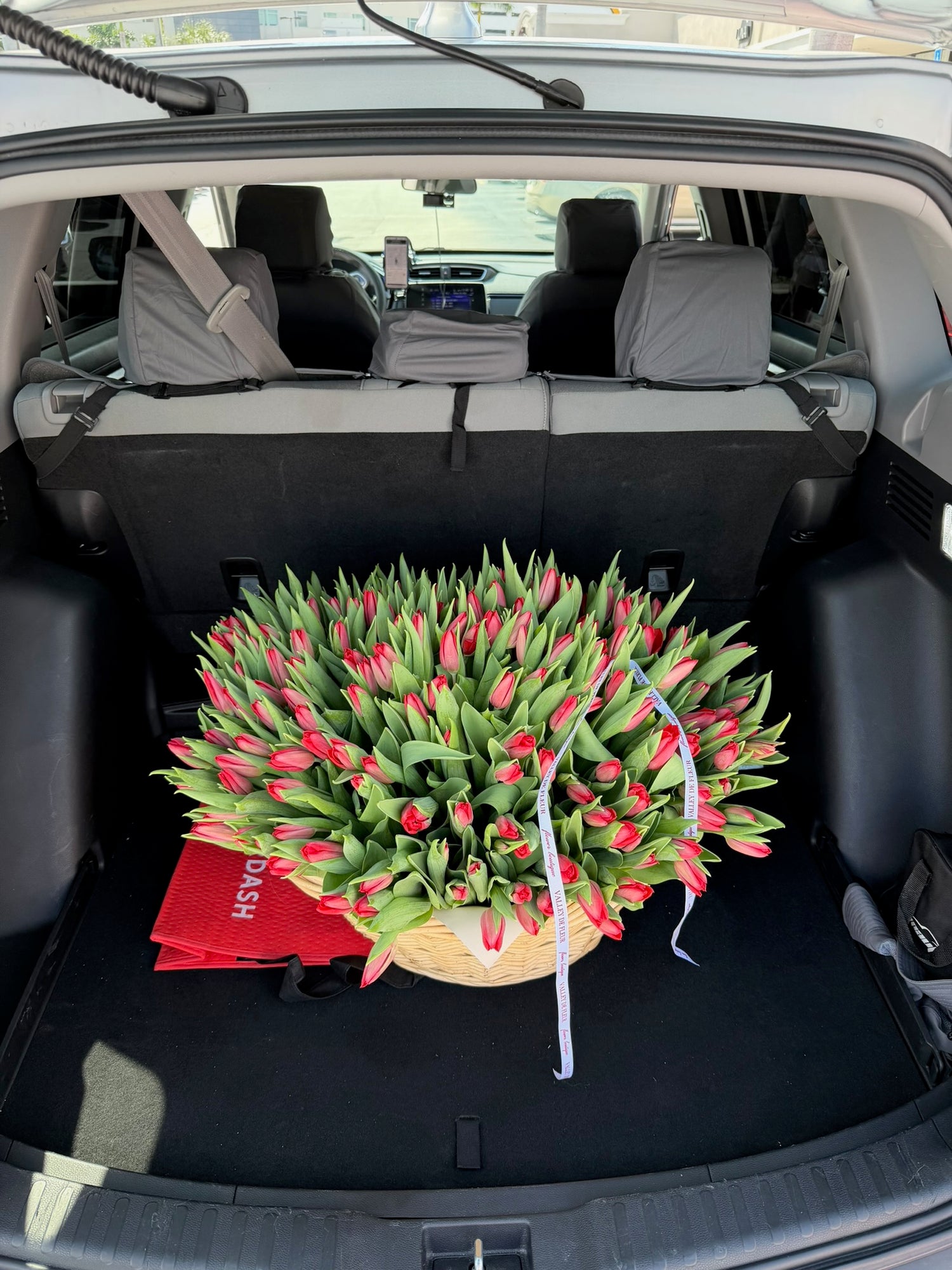 Red tulip birthday flower arrangement in a delivery vehicle, ready for delivery