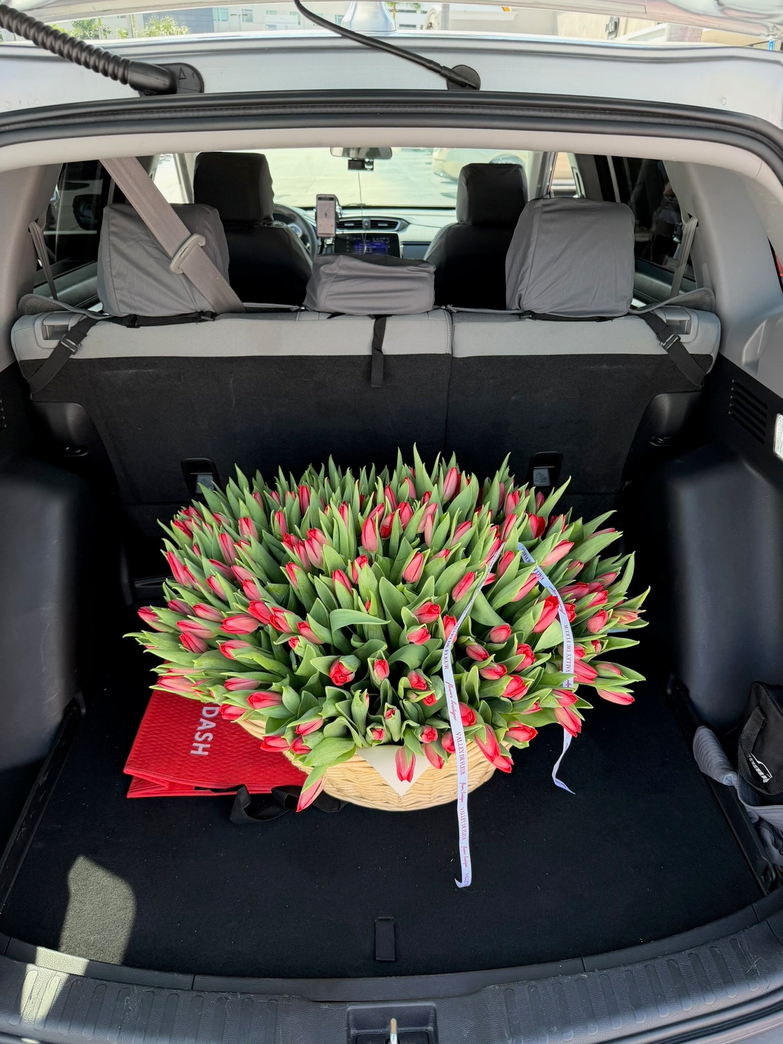 Red tulip birthday flower arrangement in a delivery vehicle, ready for delivery