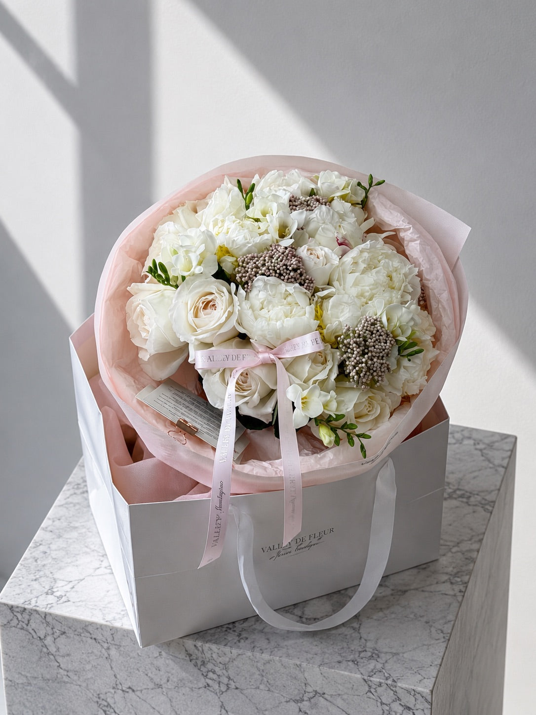 White garden roses and peonies arranged in a soft birthday flower bouquet