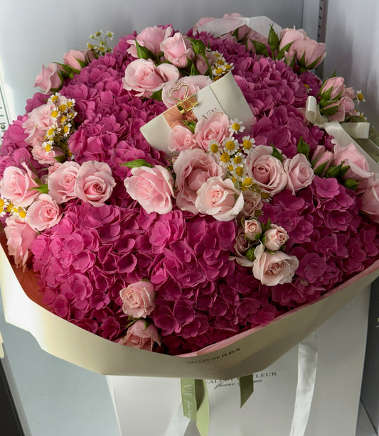 Heart-shaped bouquet featuring hydrangeas and spray roses