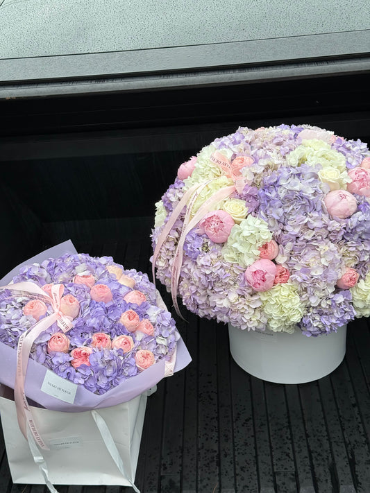 Lavender hydrangeas arranged with spray roses and peonies