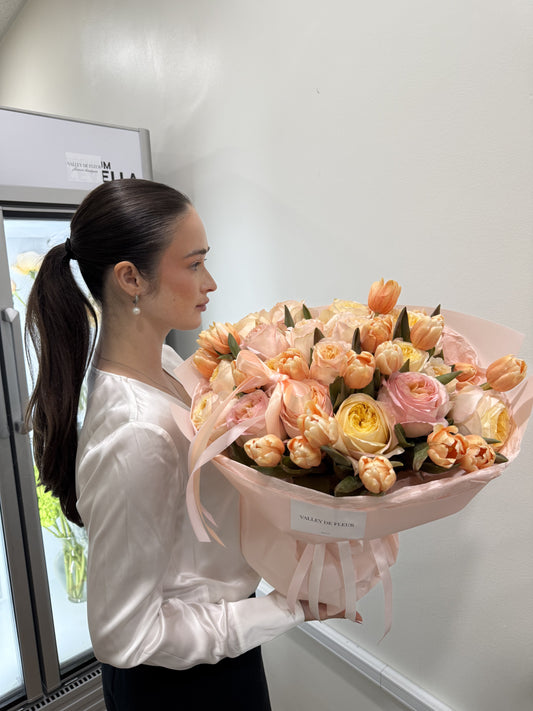 Peach Bellini rose bouquet featuring Dutch tulips and garden roses in soft peach tones.