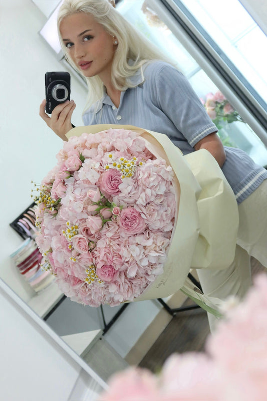 Pink hydrangeas and spray roses arranged in a floral bouquet