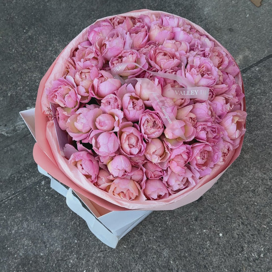 Abundant light pink spray roses with petite clustered blooms arranged in a luxurious romantic anniversary bouquet