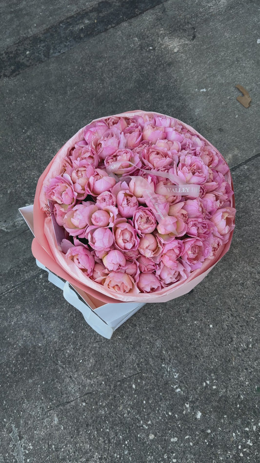 Abundant light pink spray roses with petite clustered blooms arranged in a luxurious romantic anniversary bouquet