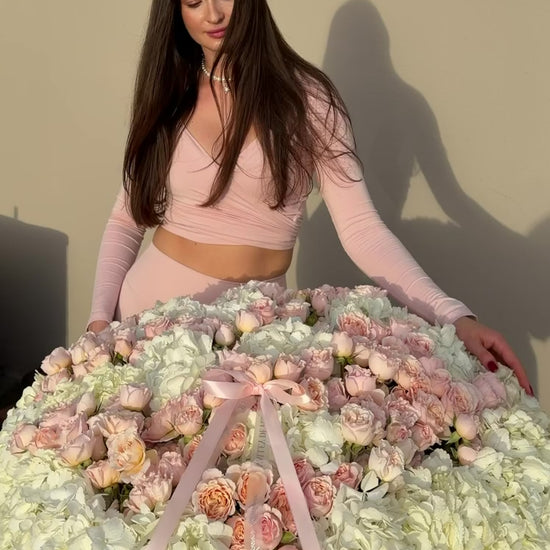 birthday flower basket with white hydrangeas, blush spray roses and pink ribbon