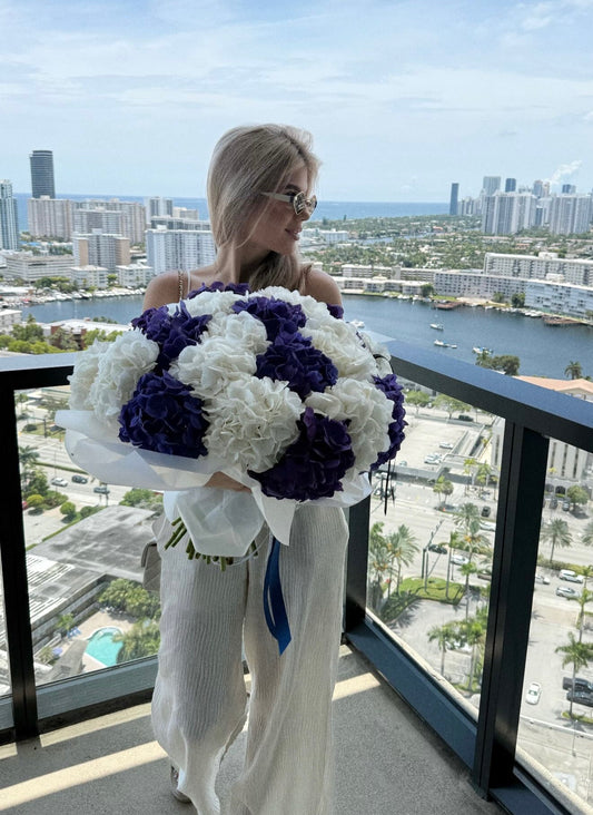 White hydrangeas paired with dark lavender hydrangeas in an elegant floral arrangement.