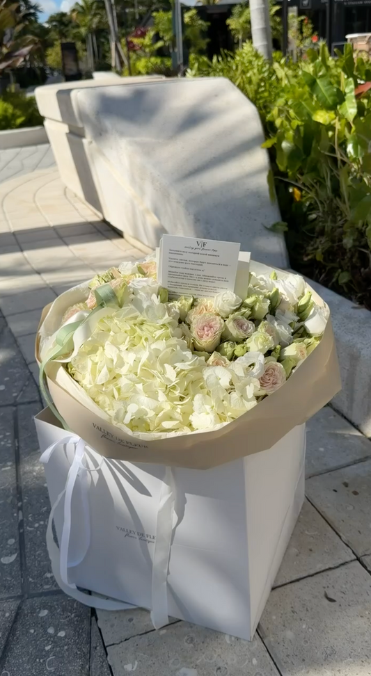 White hydrangeas and green spray roses in a fresh birthday bouquet